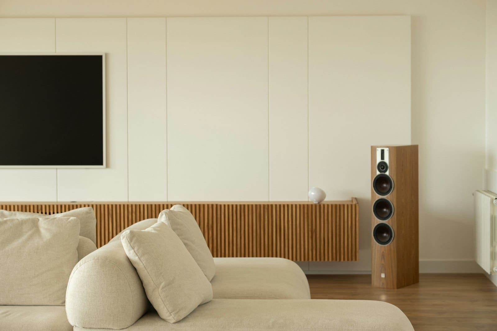 Minimal living room with a floor-standing speaker beside the sofa