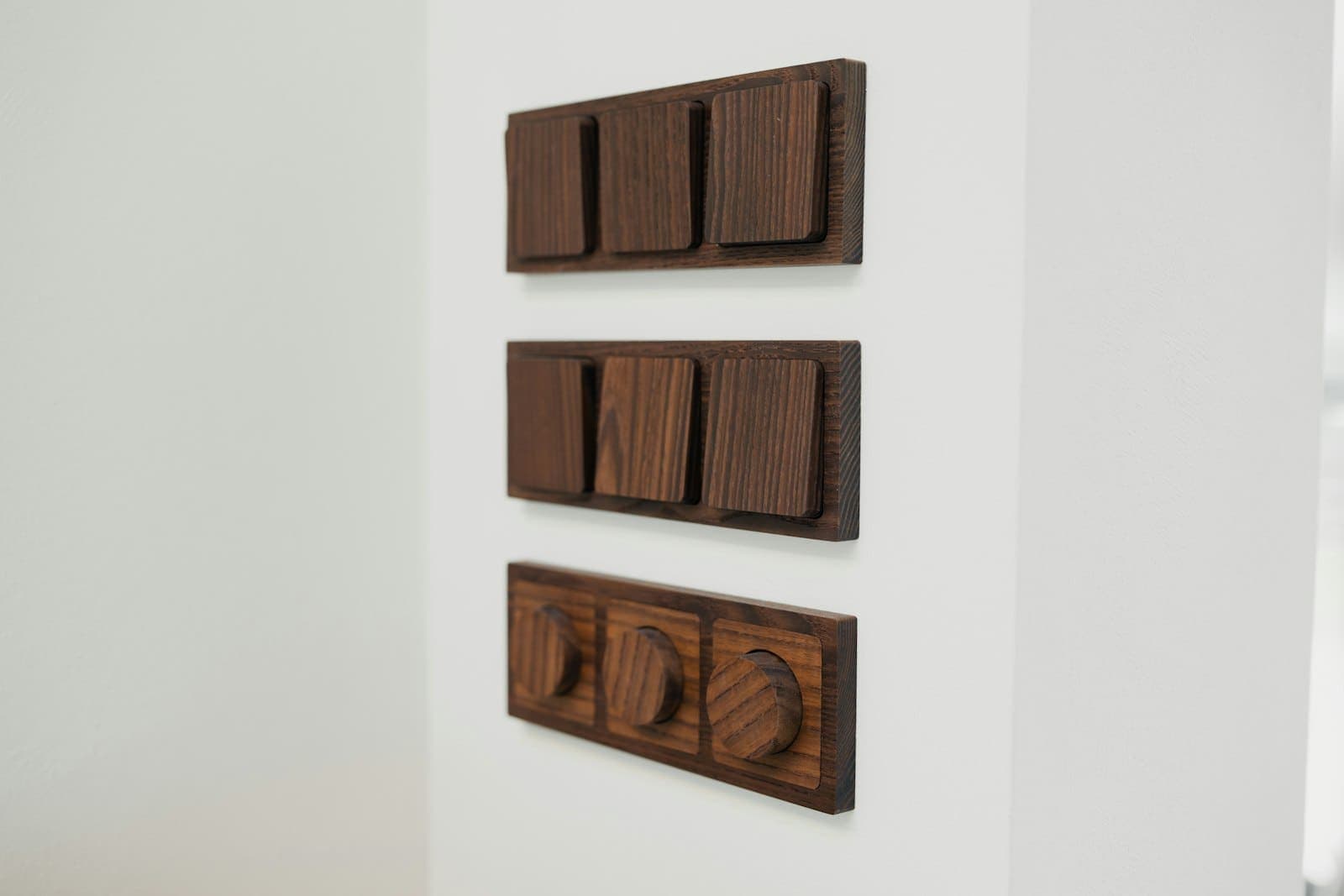 Wooden designer wall switch plates mounted on a white wall