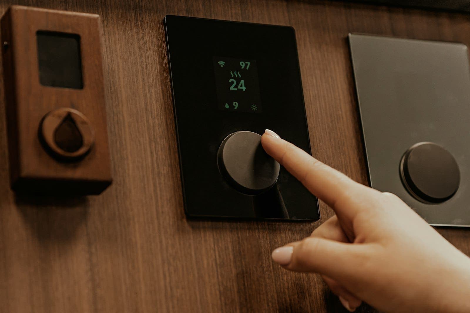 Hand holding a slim black smart-home control device